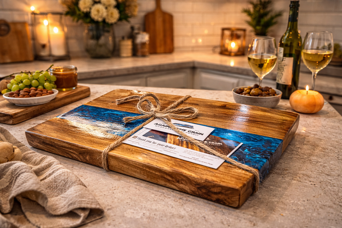 Wooden cutting board with a scenic design on a kitchen counter with wine and snacks.